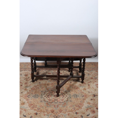 36 - A VINTAGE OAK DROP LEAF TABLE the rectangular hinged top raised on spiral twist supports joined by c... 