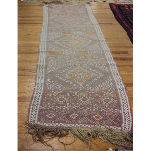 40 - A TURKISH TRIBAL RUNNER the light brown and light green ground with central diamond panels filled wi... 