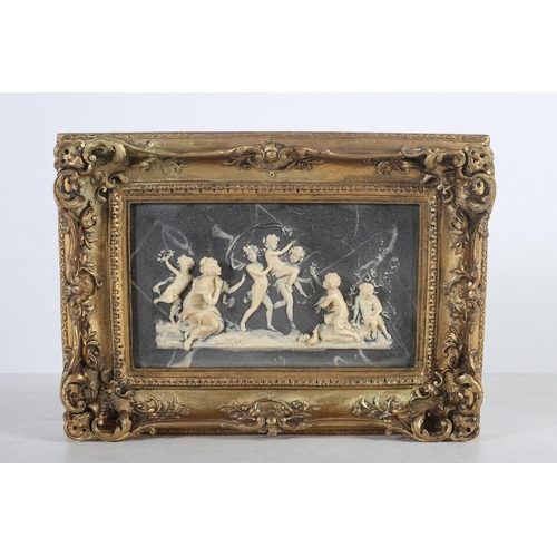 568 - A COMPOSITION PLAQUE moulded in high relief with figures in ornate gilt frame 23cm x 46cm