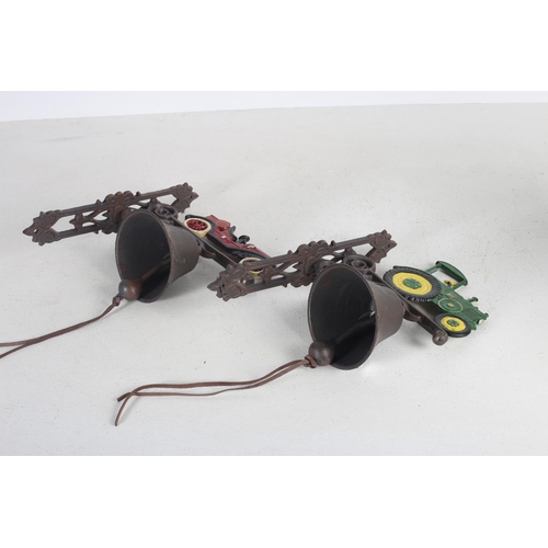 569 - A PAIR OF CAST IRON AND PAINTED WALL MOUNTED BELLS surmounted by a tractor and vintage car (2) 38cm ... 