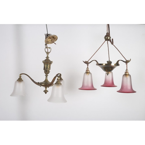 572 - A BRASS THREE BRANCH CENTRE LIGHT with ruby and frosted glass shade together with a similar example ... 