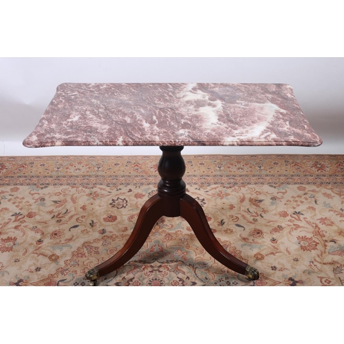 58 - A REGENCY DESIGN MAHOGANY TABLE surmounted by a rouge veined marble top with eared corners above a b... 