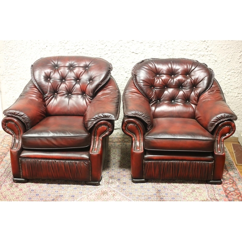 595 - A PAIR OF HIDE UPHOLSTERED ARMCHAIRS each with a button upholstered back and seat with loose cushion... 