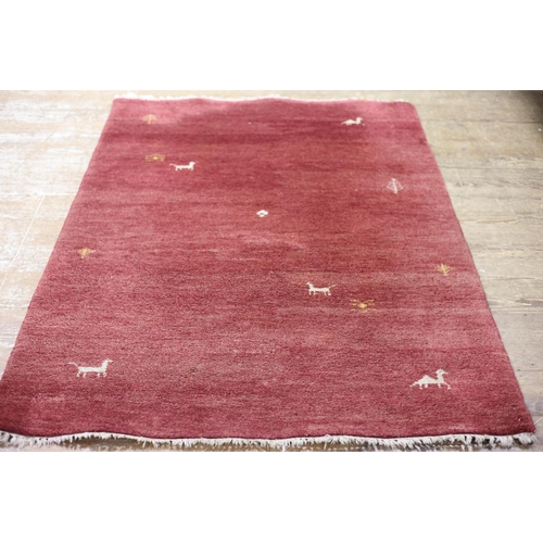 597 - A GABBEH WOOL RUG the wine fleck ground decorated with animals and trees 204cm x 136cm