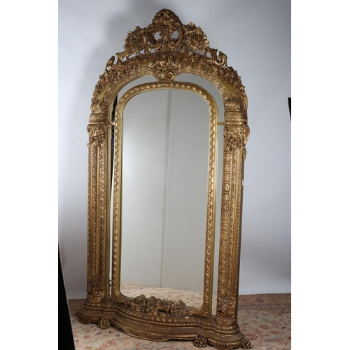 598 - A FINE CONTINENTAL CARVED GILTWOOD MIRROR the rectangular arched plate within a moulded slip the mir... 