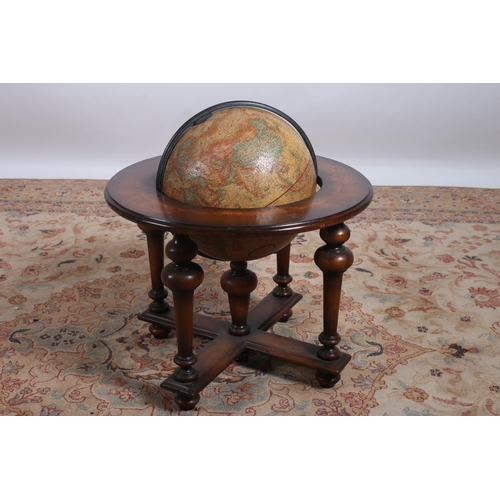 68 - A WALNUT CROSS BANDED GLOBE STAND the circular moulded top raised on cylindrical tapering supports o... 