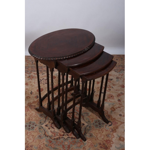 74 - A NEST OF QUARTETTO MAHOGANY CROSS BANDED TABLES the oval top with gadrooned rim containing three gr... 