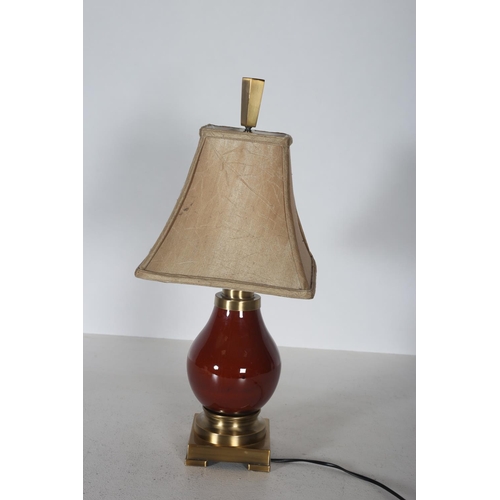 103 - A BRASS AND CHINA TABLE LAMP of bulbous form the circular foot raised on a square base with block fe... 