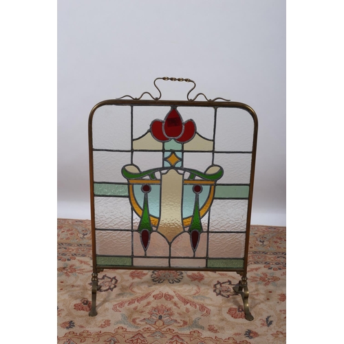 11 - A 19TH CENTURY BRASS AND STAINED GLASS FIRE SCREEN with roped carrying handle on splayed legs with p... 