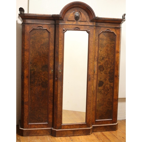 111 - A VICTORIAN WALNUT BREAKFRONT WARDROBE the rectangular arched pediment above a mirrored door contain... 