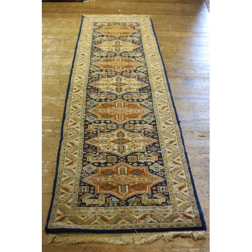 32 - A HERIZ WOOL RUNNER the beige and indigo ground filled with diamond shaped panels with serrated hook... 