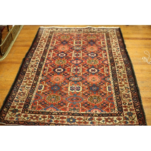 584 - AN ORIENTAL WOOL RUG the wine beige and indigo ground filled with central panel filled with palmette... 