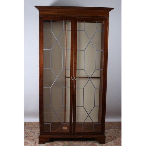 597 - A MAHOGANY WARDROBE the moulded cornice above a pair of glazed doors with applied lead strips the in... 