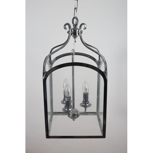 600 - A CHROME AND GLAZED THREE LIGHT LANTERN of rectangular arched form with scroll arms 56cm (h) x 29cm ... 