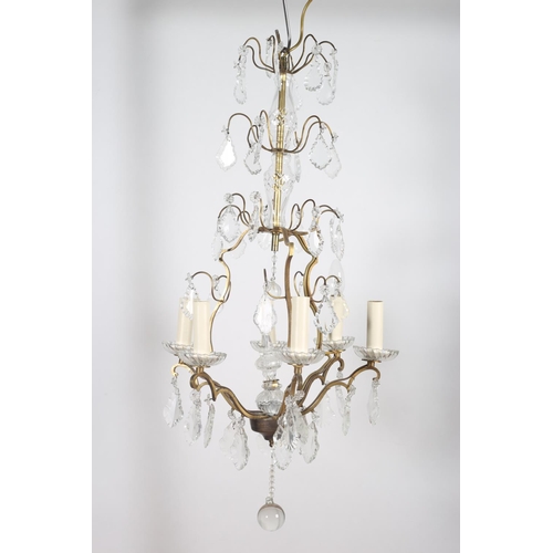 609 - A CONTINENTAL GILT BRASS AND CUT GLASS SIX BRANCH OPENWORK CHANDELIER hung with pendent drops 84cm d... 