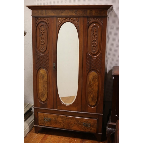 64 - A VINTAGE MAHOGANY AND WALNUT WARDROBE the moulded cornice above an oval bevelled glass mirrored doo... 