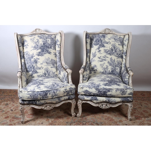 74 - A PAIR OF CONTINENTAL CREAM PAINTED WING CHAIRS each with a shaped top rail with shell cresting abov... 