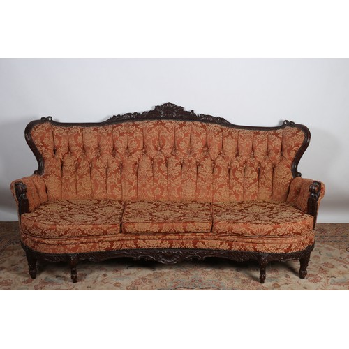 655 - A CONTINENTAL STAINED WOOD AND UPHOLSTERED THREE SEATER SETTEE the carved top rail above a button up... 