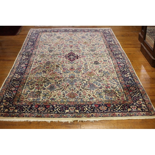 3 - A KASHAN SILK AND WOOL RUG the beige and indigo ground with central panel filled with stylized flowe... 