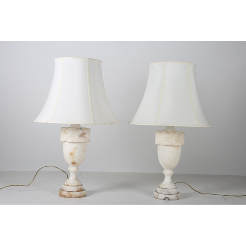 561 - A PAIR OF WHITE ALABASTER TABLE LAMPS each of urn form raised on a circular stepped base with shades... 