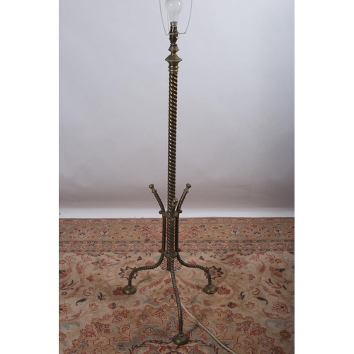 26 - A 19TH CENTURY BRASS FLOOR STANDING LAMP the spiral twist column raised on splayed legs with pad fee... 
