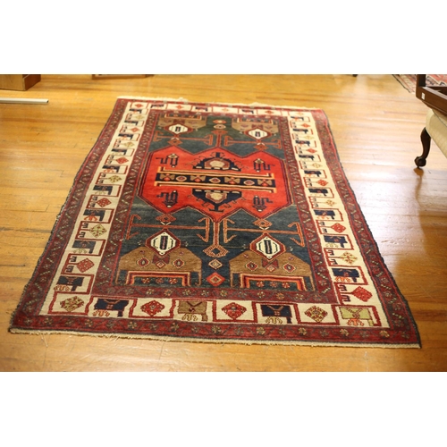 5 - AN IRANIAN TRIBAL WOOL RUG the wine and beige ground with central panel filled with stylized flowerh... 