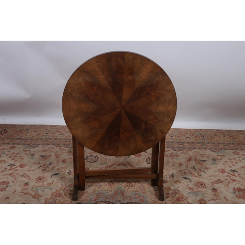 61 - A VINTAGE HARDWOOD FOLDING TABLE the circular segmented top on standard end supports with moulded le... 