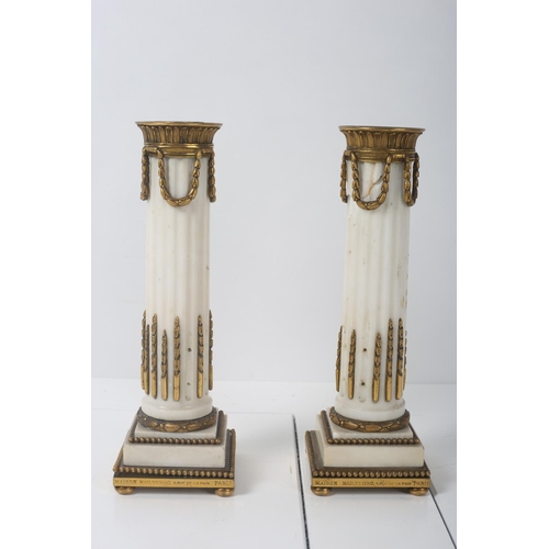 64 - A PAIR OF CONTINENTAL MARBLE AND GILT BRASS CANDLESTICKS inscribed Maison Marnyhac Paris 22cm (h)