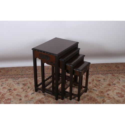 66 - A NEST OF FOUR CHINESE HARDWOOD TABLES each of rectangular outline the carved rim on foliate carved ... 