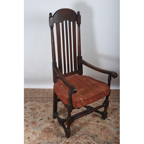 79 - A GEORGIAN OAK ELBOW CHAIR the shaped top rail above a slatted back with panelled seat and scroll ar... 