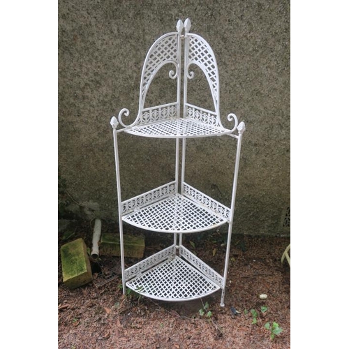 797 - A WROUGHT IRON CORNER PLANT STAND the shaped back above three graduated woven shelves on square moul... 