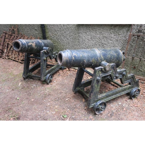 806 - A VERY FINE AND IMPRESSIVE PAIR OF 19TH CENTURY CAST IRON CANNONS raised on a two wheeled stepped ca... 