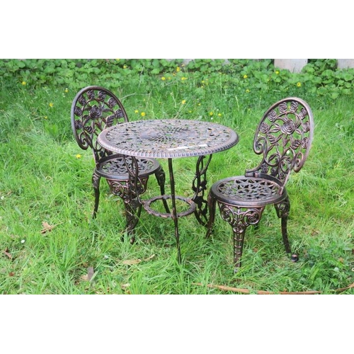 819 - A THREE PIECE CAST METAL PATIO SUITE comprising pair of chairs each with pierced flowerhead and foli... 