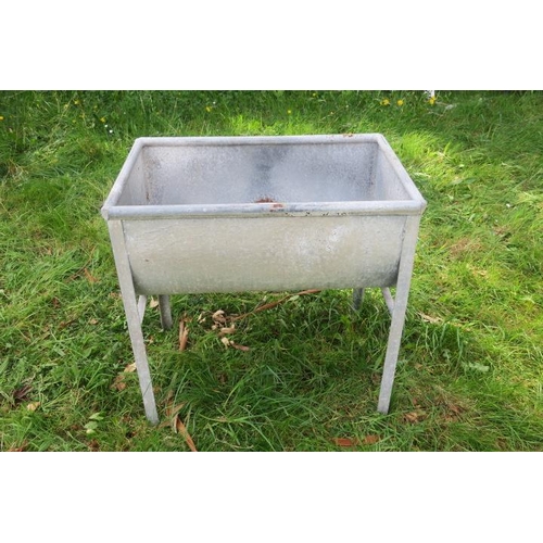 829 - A GALVANISED TROUGH of rectangular bowed outline with bung holes raised on moulded legs 83cm (h) x 8... 