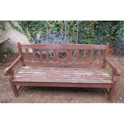 849 - A TEAK GARDEN SEAT with vertical splats above a slatted panelled seat with scroll arms and square mo... 