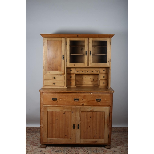 85 - A VINTAGE PINE DRESSER the moulded cornice above a pair of glazed and blind panelled cupboards with ... 