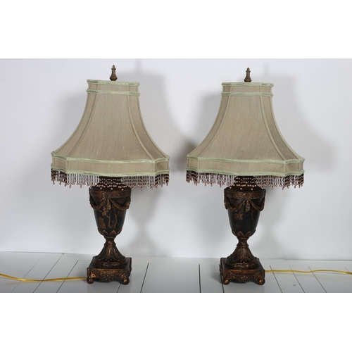 111 - A PAIR OF CONTINENTAL POLYCHROME AND GILT TABLE LAMPS each of urn form hung with swags raised on a c... 