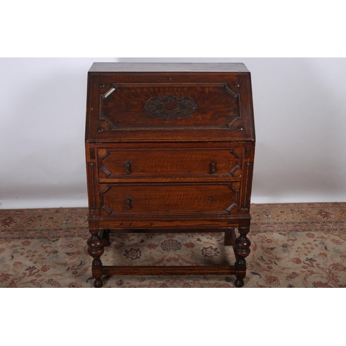 18 - A VINTAGE OAK BUREAU the hinged writing slope with pigeon holes and drawers above two long drawers o... 