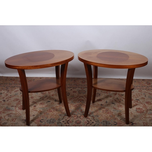 3 - A PAIR OF CONTINENTAL MAHOGANY TWO TIER TABLES each of oval outline the shaped top raised on sabre l... 