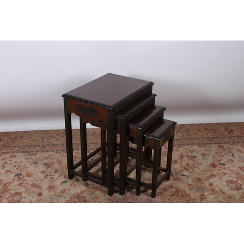 42 - A NEST OF FOUR CHINESE HARDWOOD TABLES each of rectangular outline the carved rim on foliate carved ... 