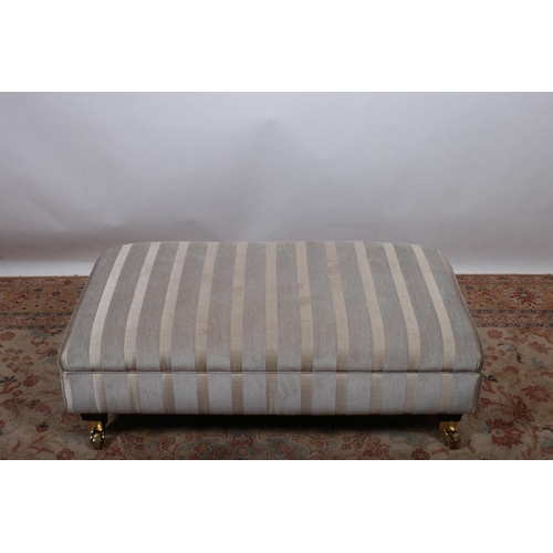 68 - AN UPHOLSTERED FOOTSTOOL of rectangular outline raised on square tapering legs with brass caps and c... 