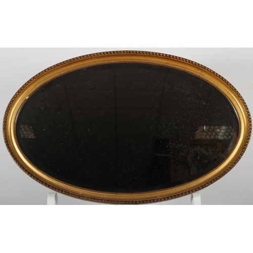 682 - A GILTWOOD AND GESSO MIRROR the oval bevelled glass plate within a beadwork and roped frame 52cm x 8... 