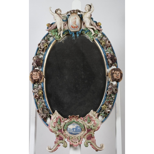 685 - A 19TH CENTURY CONTINENTAL PORCELAIN MIRROR the oval plate within a flower encrusted frame with figu... 