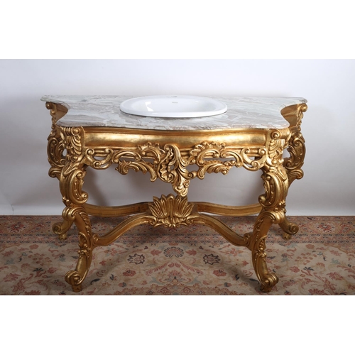 688 - A CONTINENTAL GILTWOOD AND MARBLE VANITY UNIT OF SERPENTINE OUTLINE surmounted by a veined marble to... 