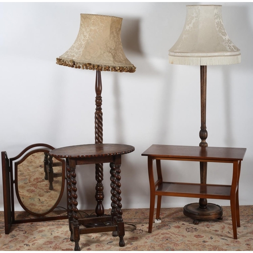 694 - A VINTAGE OAK TABLE of oval outline on barley twist legs together with two floor standing lamps a te... 