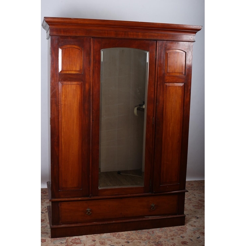 8 - A VINTAGE MAHOGANY WARDROBE the moulded cornice above a bevelled glass mirrored door containing hang... 