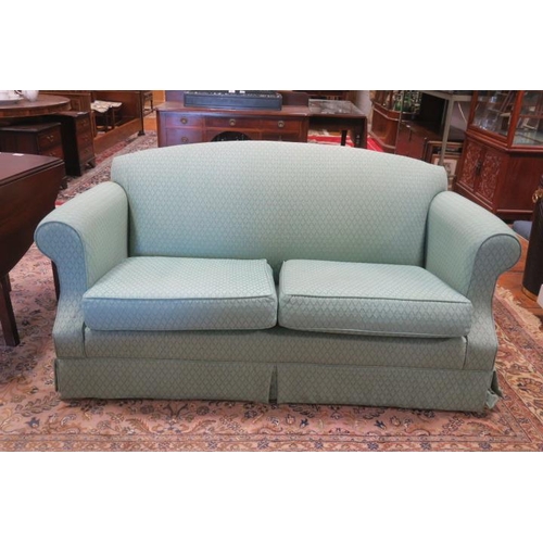 412 - A TWO SEATER SETTEE the rectangular arched back with scrollover arms and loose cushions on bun feet
... 