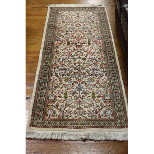 414 - A HERIZ RUNNER the beige ground with light blue and pink floral sprays within a conforming border 22... 