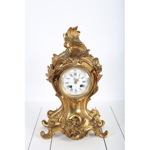 89 - A FRENCH GILT BRASS MANTLE CLOCK the shaped case moulded in relief with flowerheads and foliage cont... 