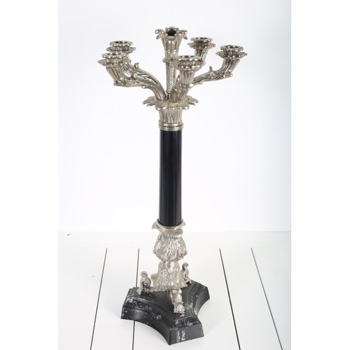 93 - A SILVER PLATED AND COMPOSITION FIVE BRANCH CANDELABRUM the foliate arms above a reeded and leaf cap... 